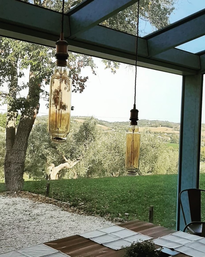 Veranda con lampade a sospensione e vista sulle colline, homepage reale del sito Ikon Arredamenti